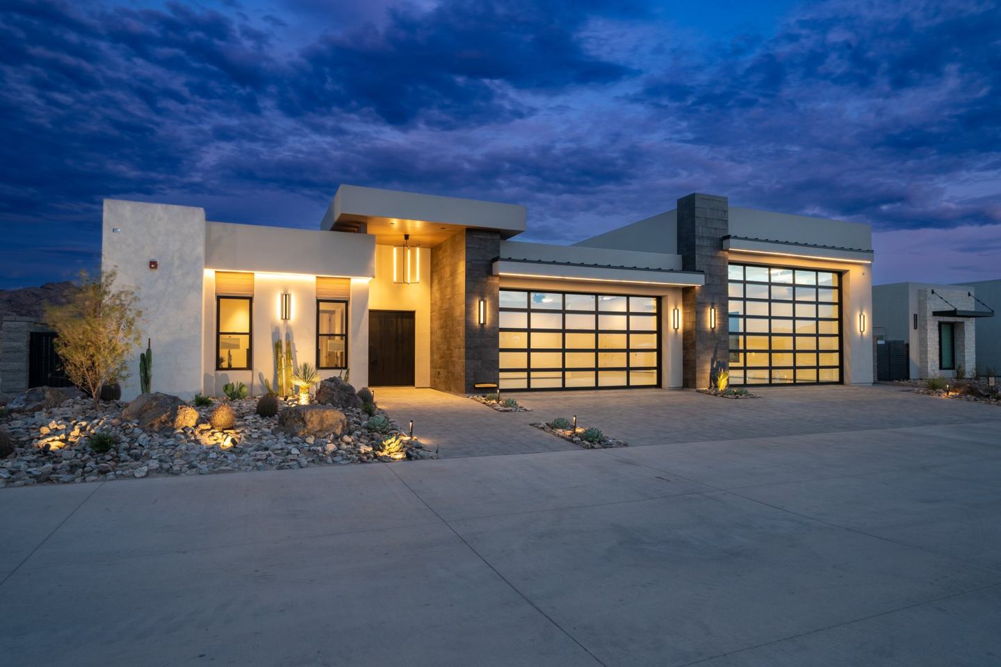 Wide front elevation of a modern desert custom home at twilight