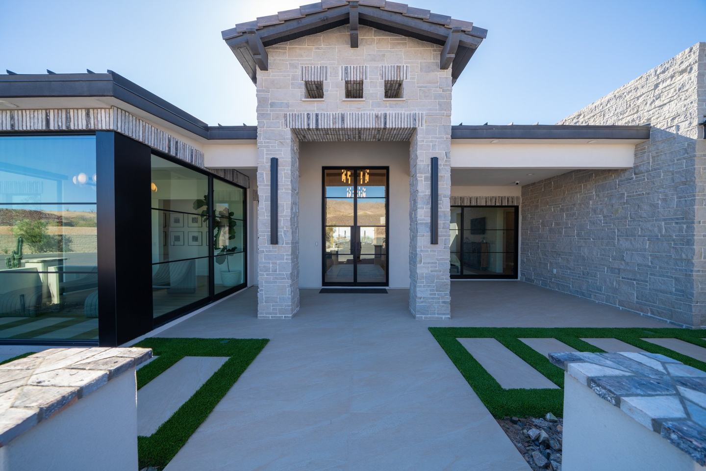 Stone entry courtyard with steel and glass front doors