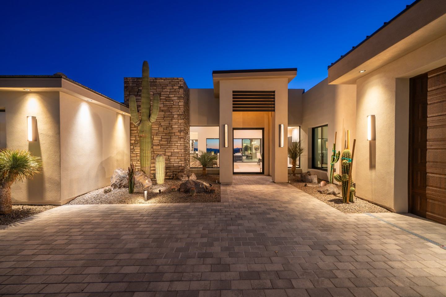 Entry courtyard with a mature saguaro and stacked stone at twilight