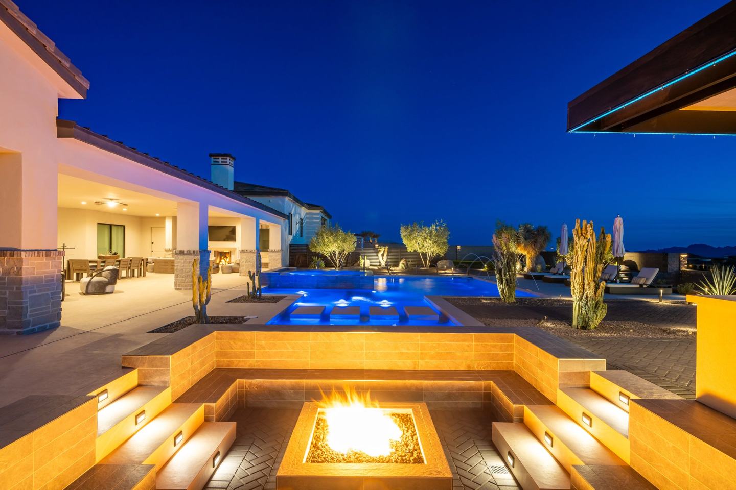 Sunken fire pit lounge overlooking the pool at twilight