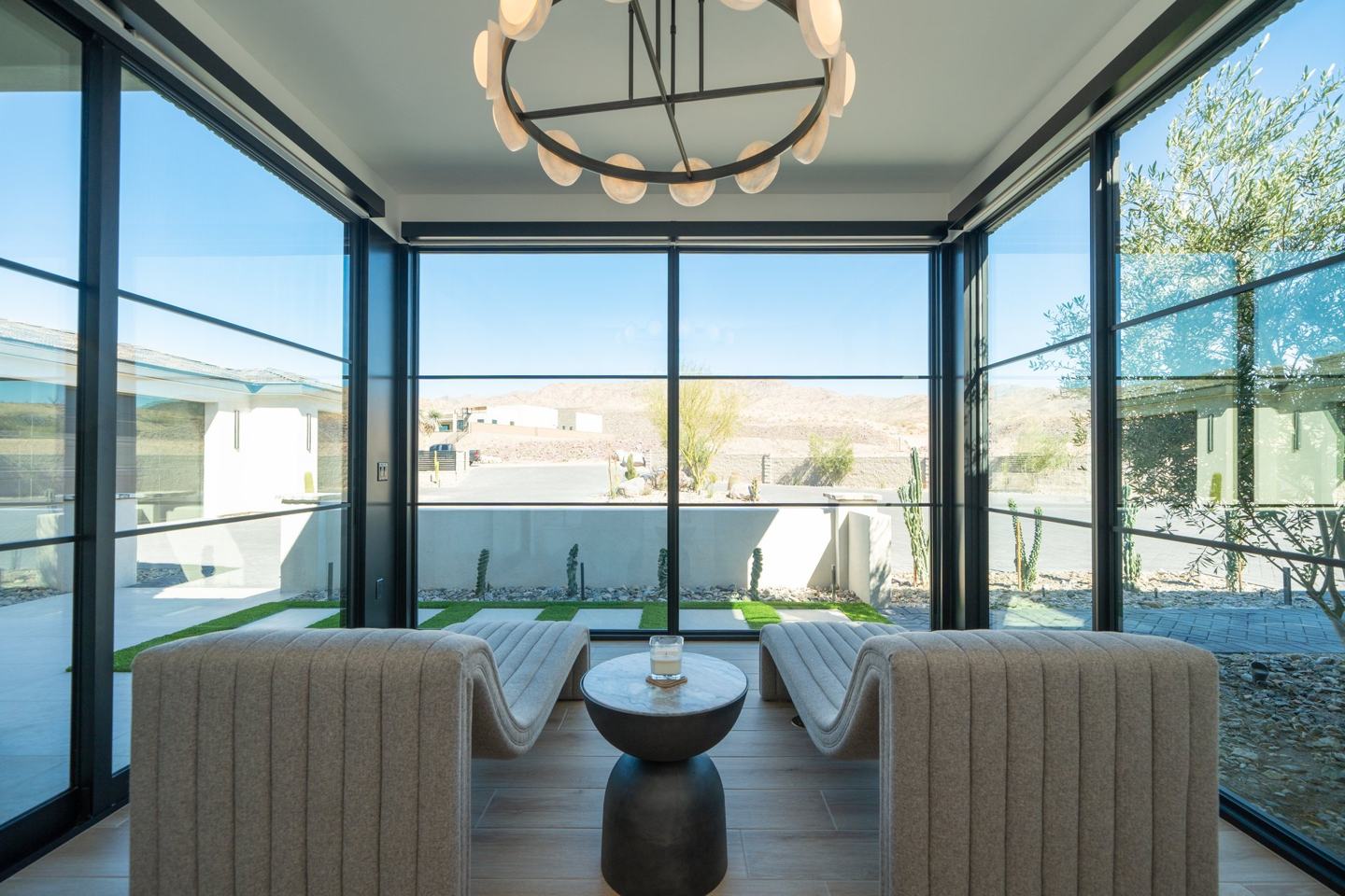 Glass walled sitting room with curved benches and desert views
