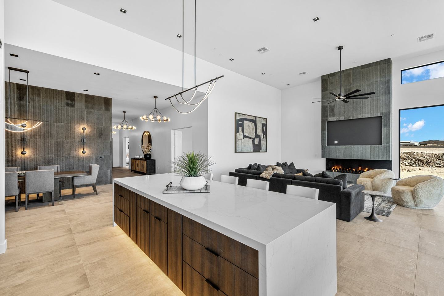 Espresso island kitchen with a stone fireplace wall and open dining beyond