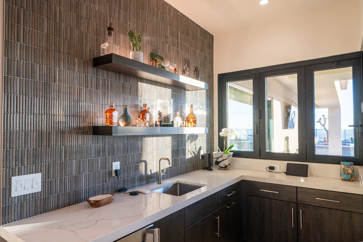 Butler's pantry galley kitchen with gray cabinetry and marble backsplash