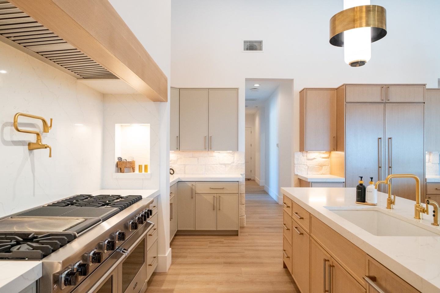 Prep pantry with dark cabinetry, stainless refrigerator, and marble counters