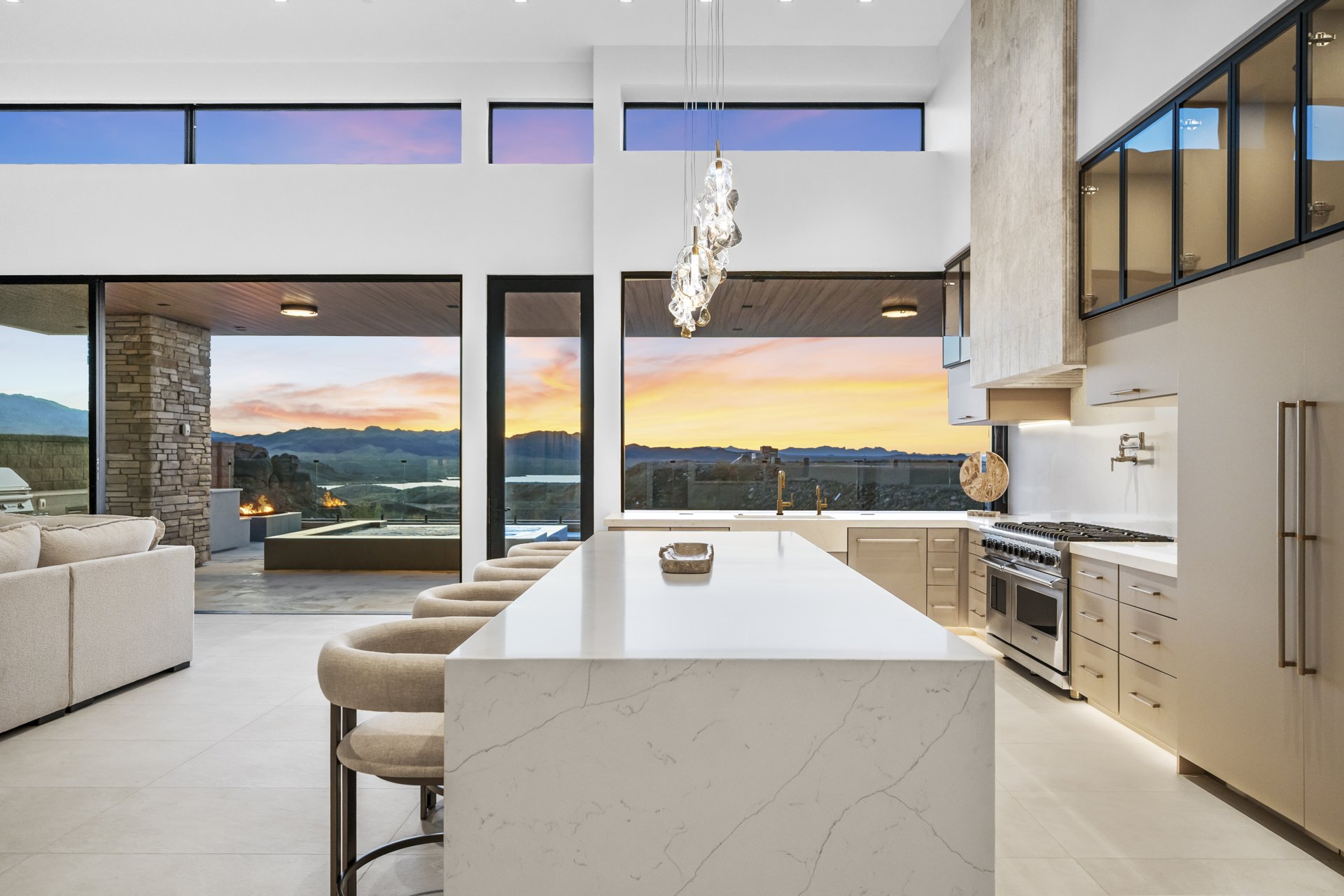 Waterfall island kitchen opening to a desert sunset