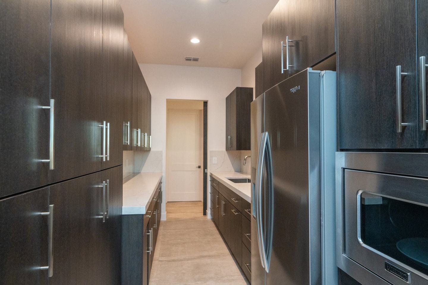 White oak cabinetry with a stone waterfall hood