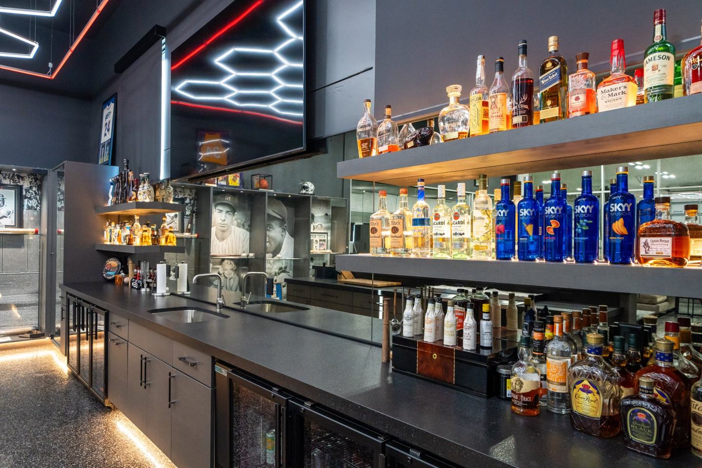 Backlit floating shelves with a curated whiskey collection