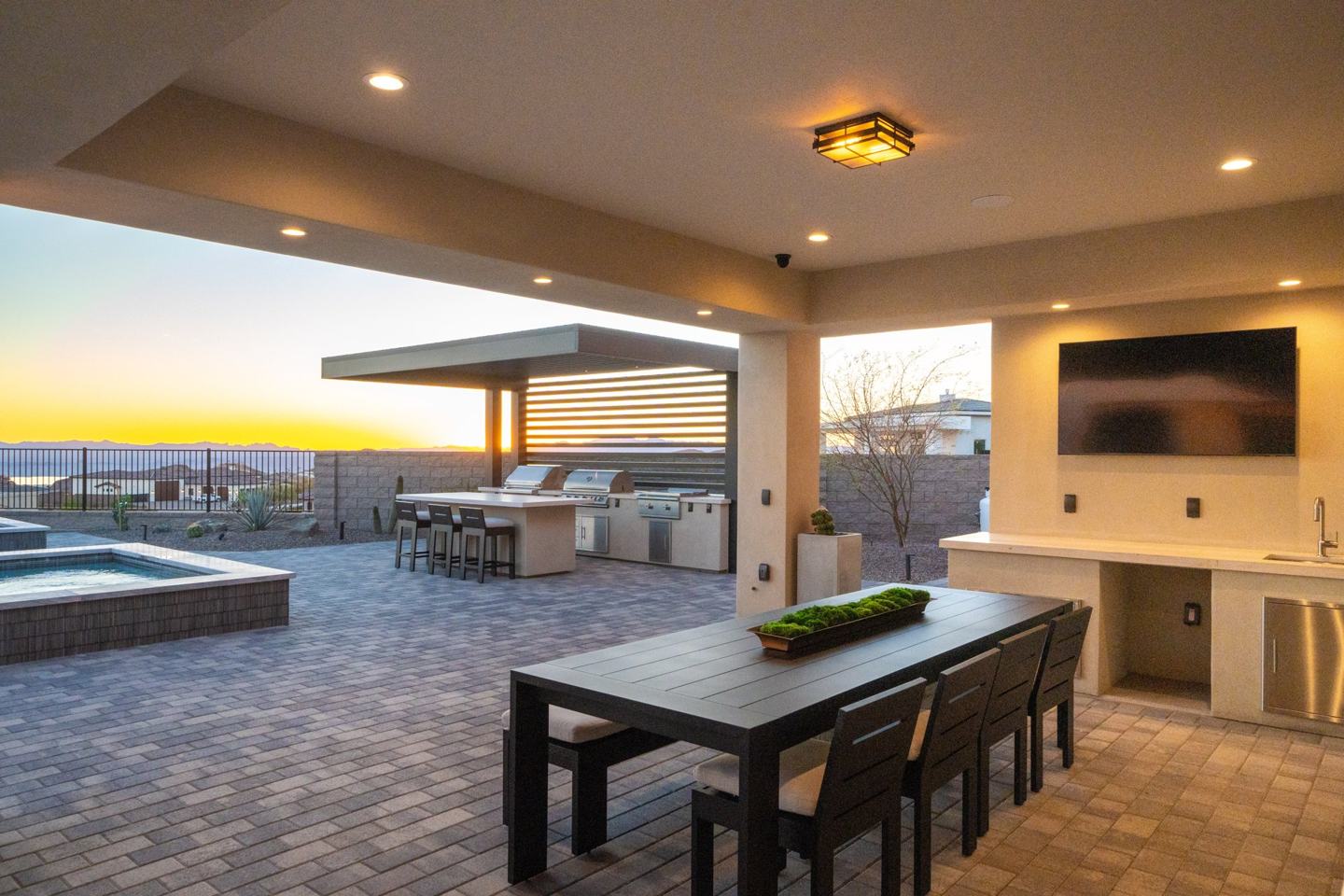 Covered outdoor dining and pergola kitchen at sunset