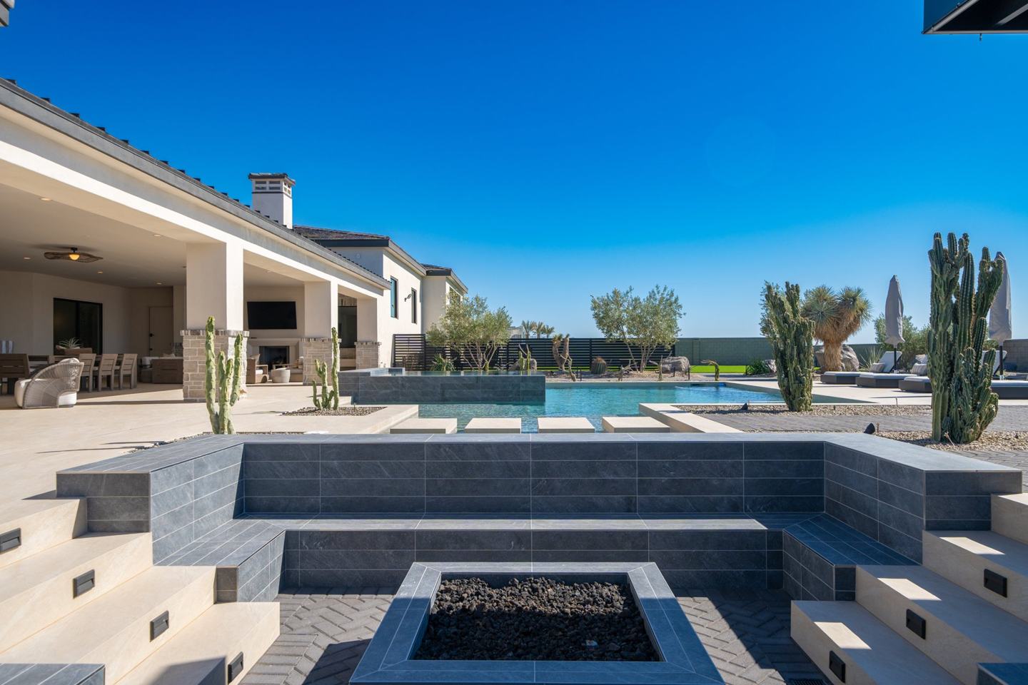 Sunken tiled fire pit lounge beside the pool with desert landscaping