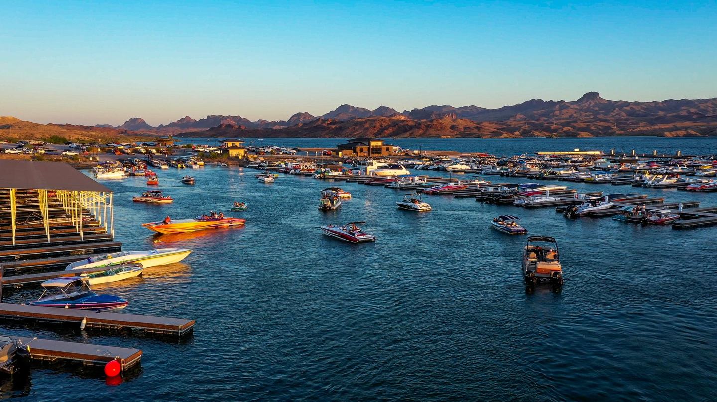 Boats and slips at Havasu Riviera Marina at golden hour with the lake and mountains beyond