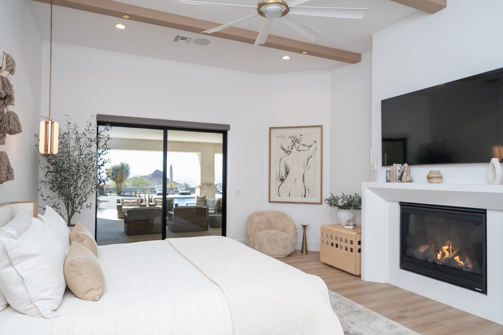 Primary suite with a fireplace and sliding glass to the pool