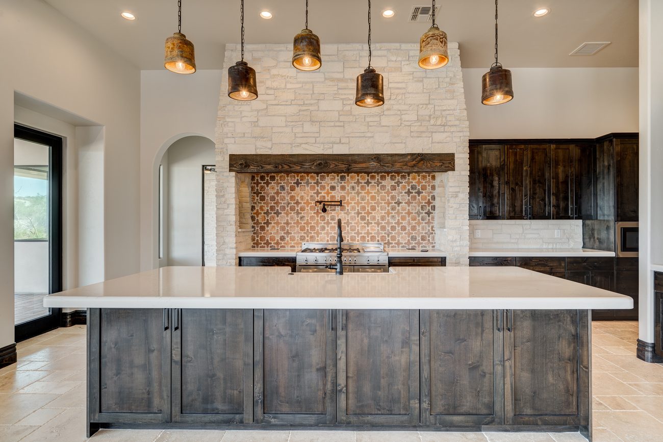 Island kitchen with white stone range hood